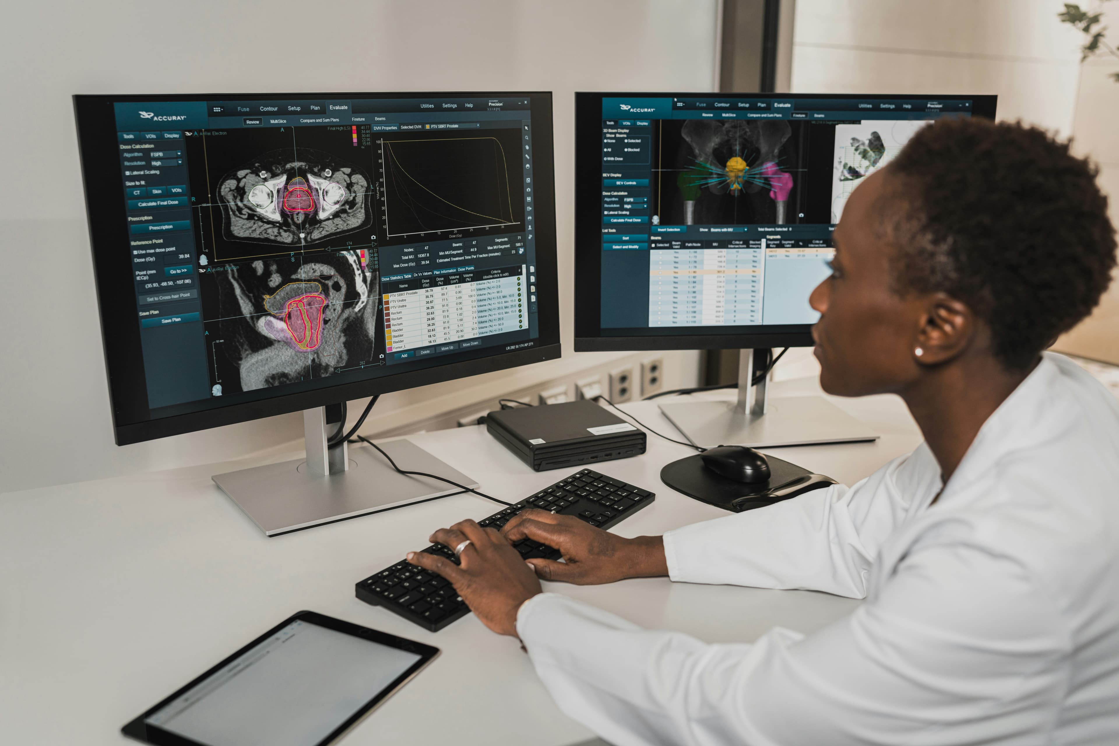A clinician reviewing patient information across two monitors