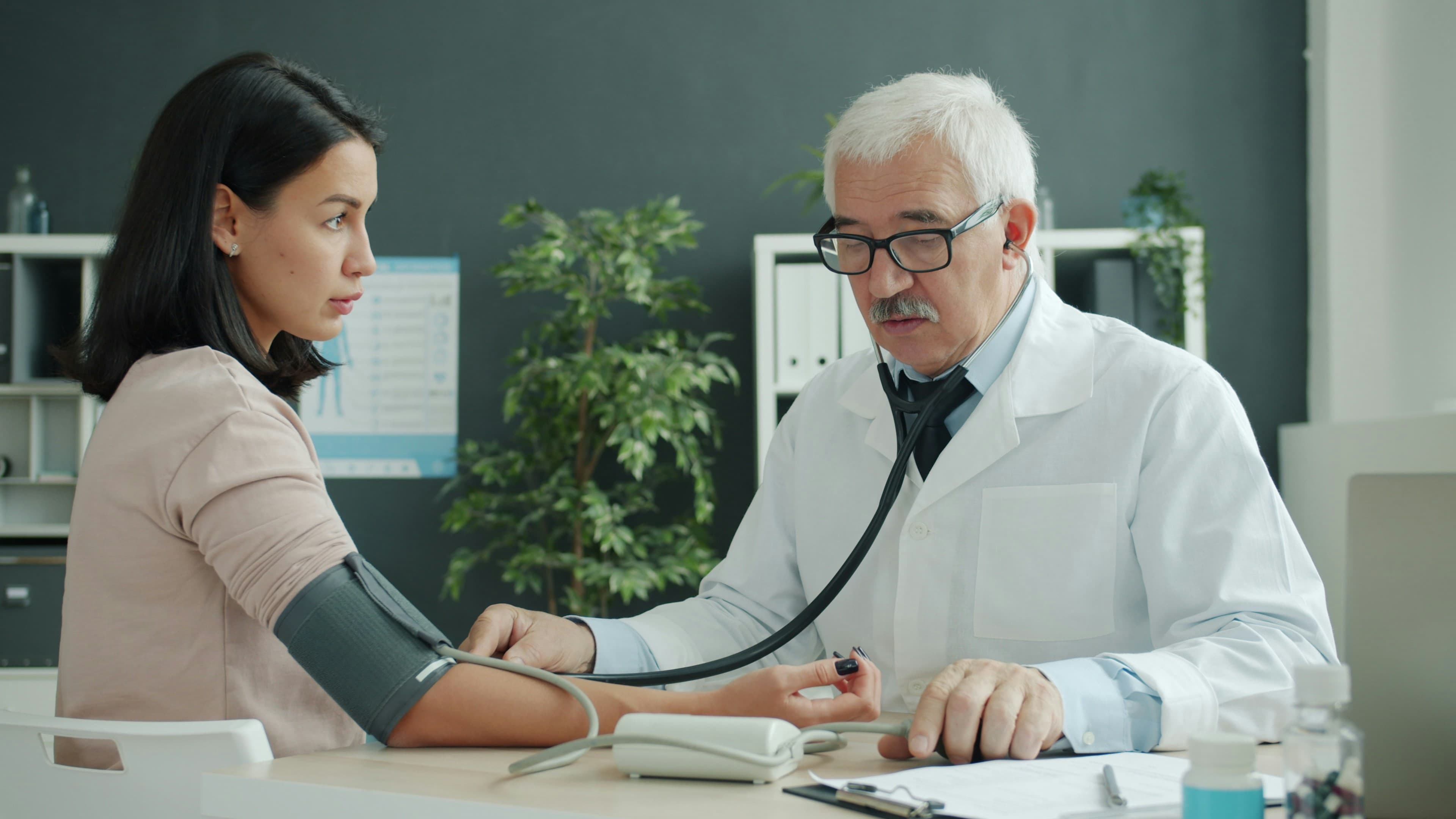 A doctor checking a patient's blood pressure