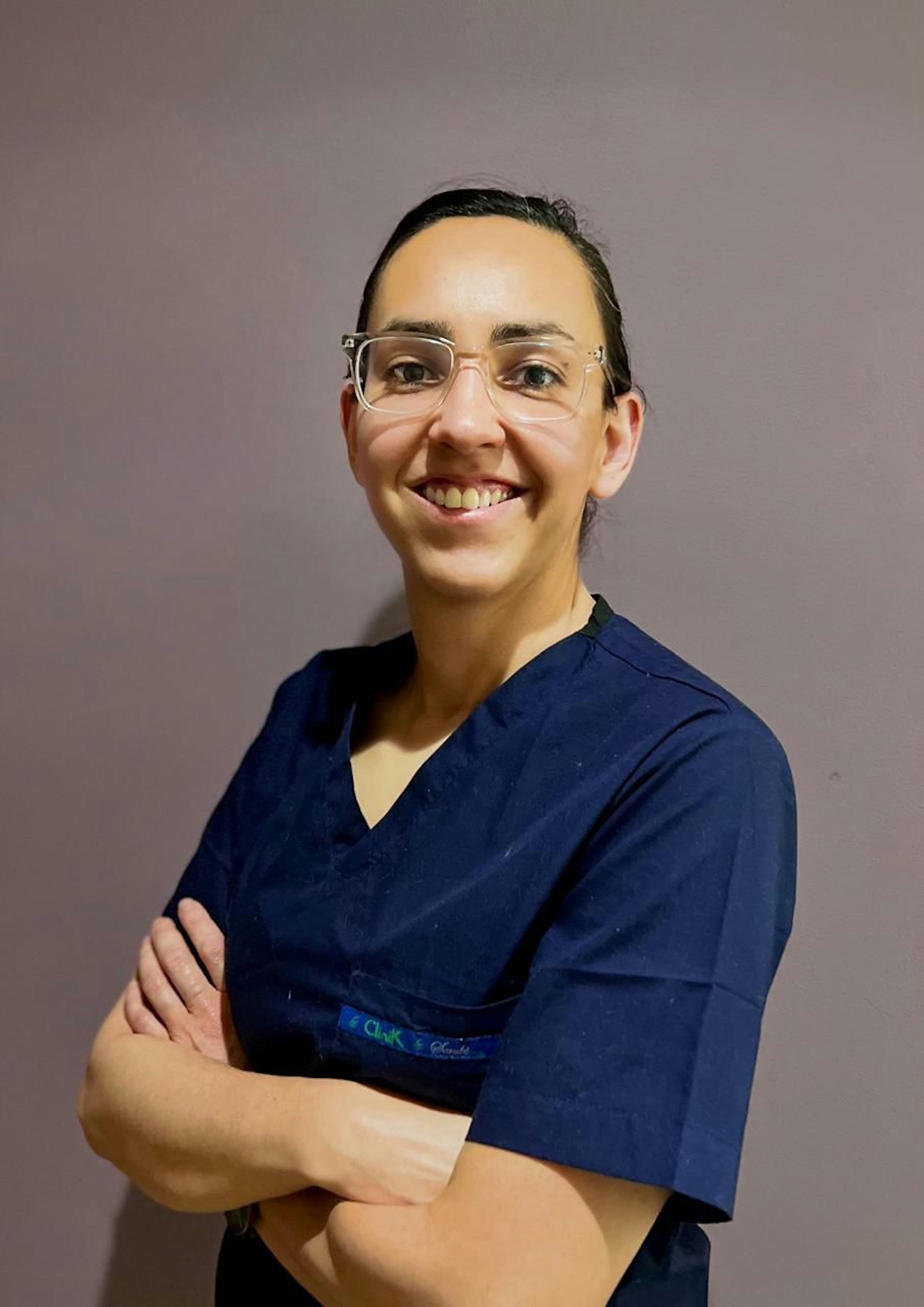 A smiling practice manager in scrubs