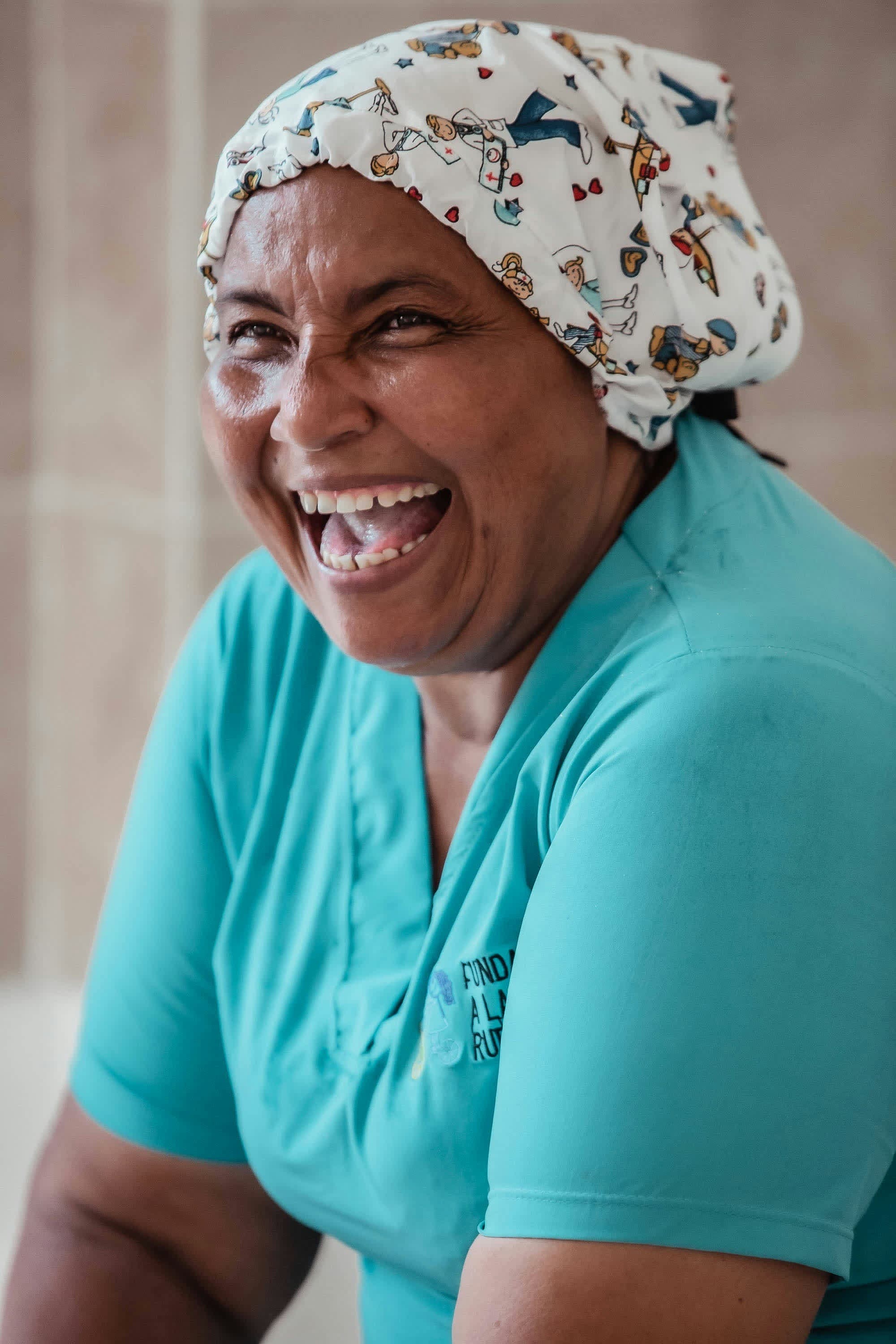 A nurse in scrubs laughing, relaxed at work